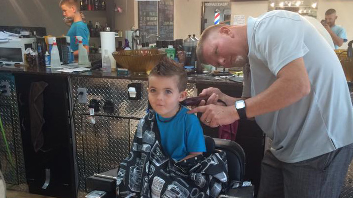 Erick cutting kid's hair